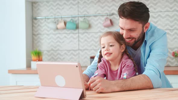 Young father and daughter looking cartoon on laptop at home