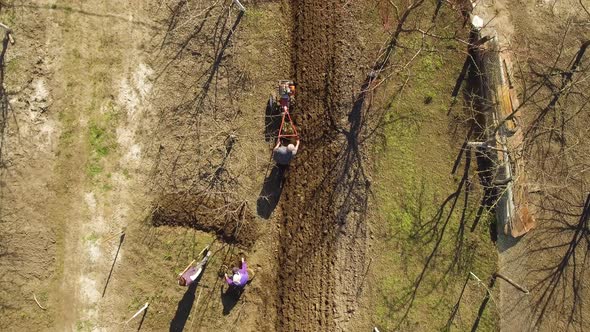 Aerial View, Caucasian Farmers Furrowing Soil and Preparing Field for Planting of Vegetables. Men