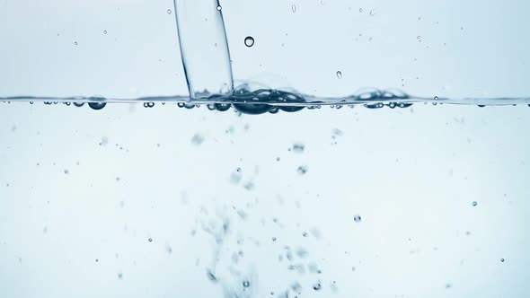 Pouring water in glass close up low angle