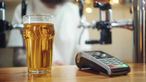 Buying Beer and Paying By Smartwatch Via Terminal Closeup