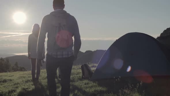 Young Friends Doing Camping Looks at Sun in Mountain Outdoor Nature Scenery During Summer Sunrise or