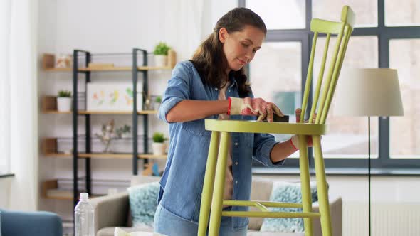 Woman Sanding Old Round Wooden Chair with Sponge