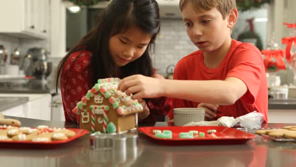 Decorating gingerbread house for Christmas alt