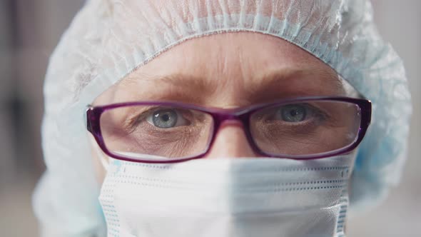 Cropped Shot of Doctor Face in Medical Mask and Cap Looking at Camera