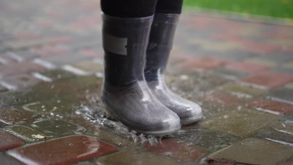 Closeup Waterproof Rubber Boots Stepping in Puddle Outdoors