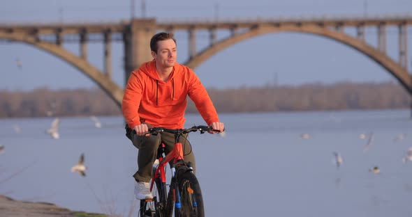 Bicyclist Riding Bike at River Embankment Slow Motion