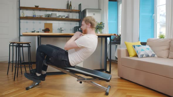 Young Man Doing Fitness Exercises on Home Gym Bench.