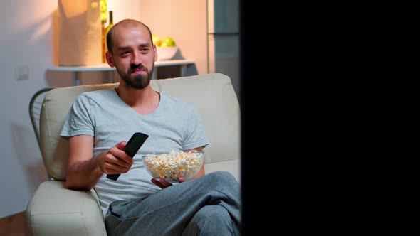 Man Late at Night in His Apartment Looking at TV Entertainment