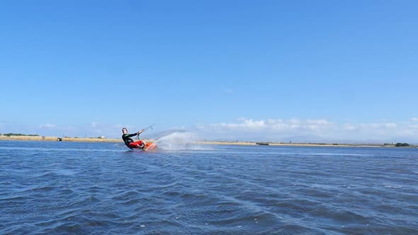 A man kiteboarding and doing a jumping trick on a kite board.