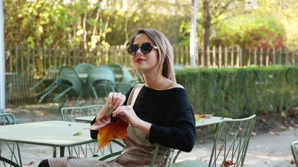 Young girl in sunglasses sitting chair in cafe. Autumn season time