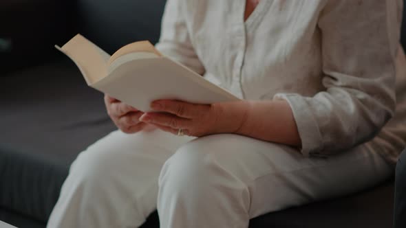 Grandmother Reading Novel Story Book in Living Room