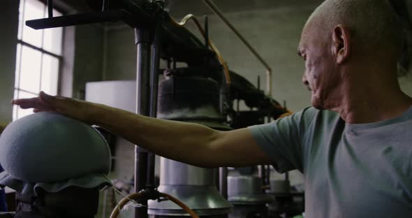 Mixed race man working at a hat factory