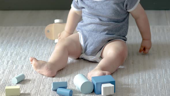 cute baby boy playing with eco wooden toys,train with carriages with cylinders and square form shape