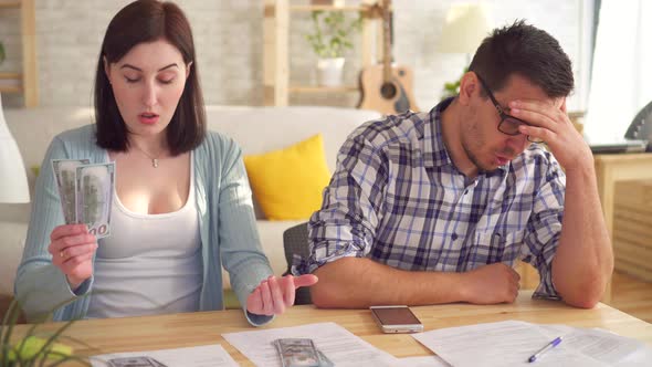 Close Up Young Couple Concerned and Tense Doing the Calculations Documents with Calculator