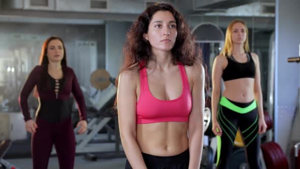 A Group of Athletic Women Warm Up and Stretch in the Gym. Concept of Bodybuilding, Workout, Sport.