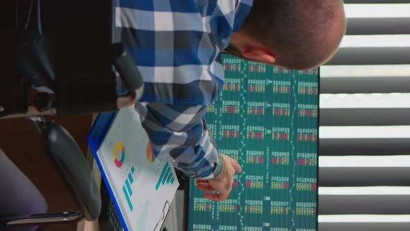 Man Checking Graphs Sitting Immobilized in Wheelchair