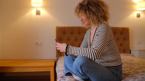 Curly white female using smartphone for internet communication in 4k stock video