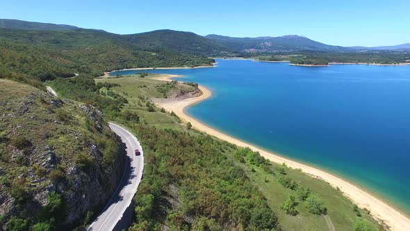 Aerial view of paved road passing artificial lake of Peruca, Croatia alt