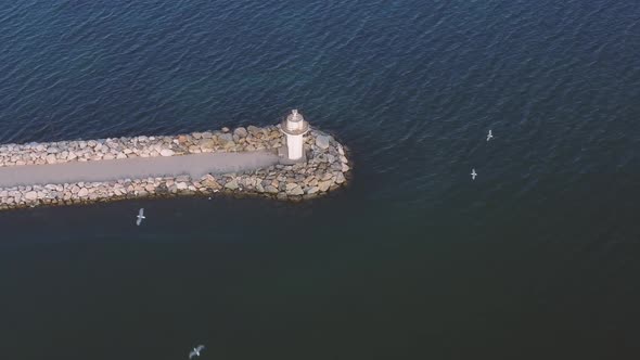 Panorama Drone Shot of a Lighthouse at Golden Hour with Ocean and Sun