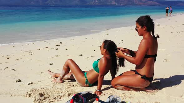 Tourists posing on marine island beach journey by transparent water and white sand background of Gil