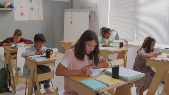 Kids Writing in Notebooks During Lesson