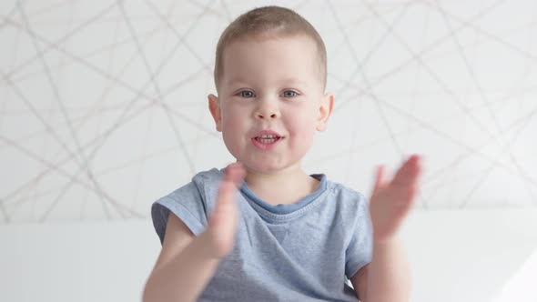 Happy Child Kid Boy Portrait Clapping Hands Cheering Smiling Having Fun Indoors