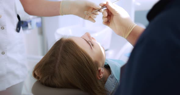 the Dentist Performs an Examination Using a Dental Mirror a Woman
