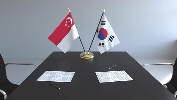 Flags of Singapore and South Korea on the Table