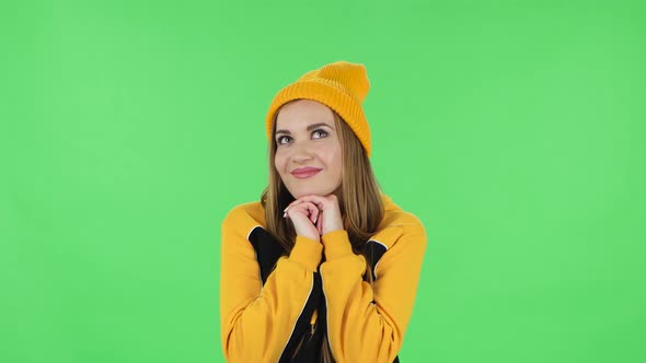 Portrait of Modern Girl in Yellow Hat Is Daydreaming and Smiling Looking Up