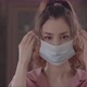 Woman Placing A Surgical Mask Over Her Face And Staring Directly At The Camera Close Up - VideoHive Item for Sale