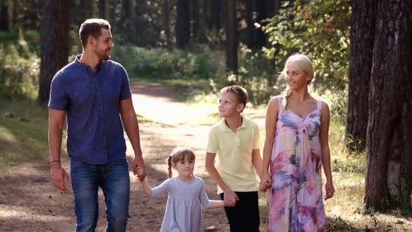 Family is Walk on Green Grass in Natural Park