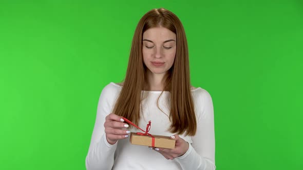 Portrait of Pretty Young Woman Is Opening the Gift with a Very Surprise and Is Surprised 