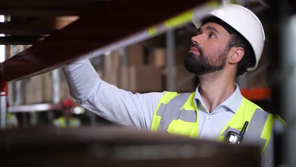 Focused Supervisor Taking Inventory in Storehouse