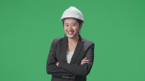 Smiling Asian Female Engineer Crossing Her Arms And Shaking Her Head In The Green Screen Studio