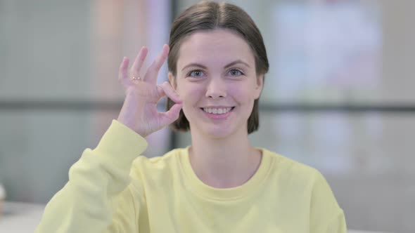 Portrait of Young Woman Showing Ok Sign with Finger