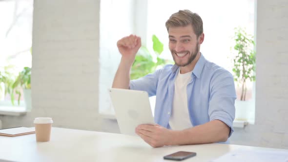 Successful Young Creative Man Celebrating on Tablet