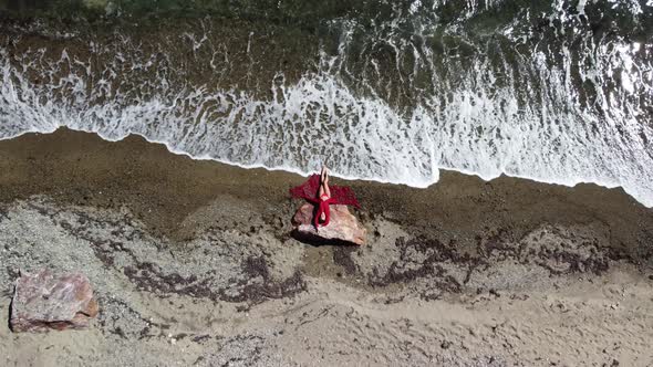 Top Aerial View on a Young Sensual Blonde Woman in Red Bikini Lying on the Rock Near Water at Sea