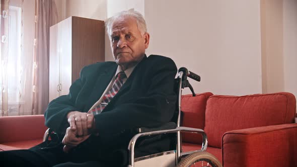 Elderly Grandfather - Grandfather Is Sitting in a Wheelchair and Looking at the Camera