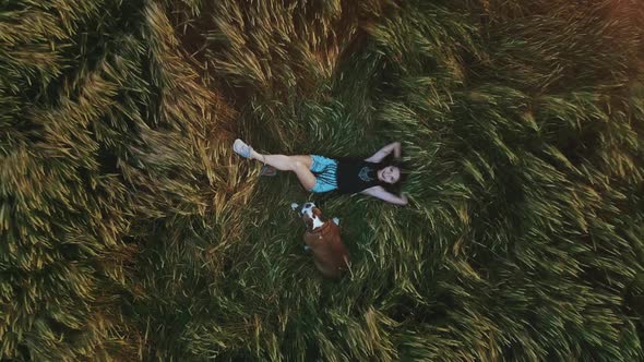 Beauty Girl with Summer Cowboy Hat Outdoors. Happy Smiling Young Woman Falling Down on the Yellow