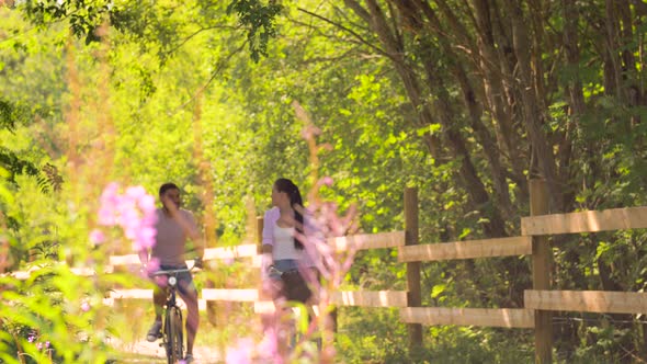 Happy Couple Riding Bicycles at Summer Park