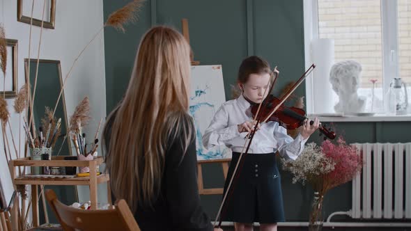 A Girl Learning Playing Violin with Her Blonde Woman Teacher