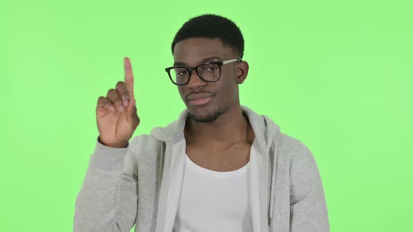 African Man Showing No Sign By Finger on Green Background