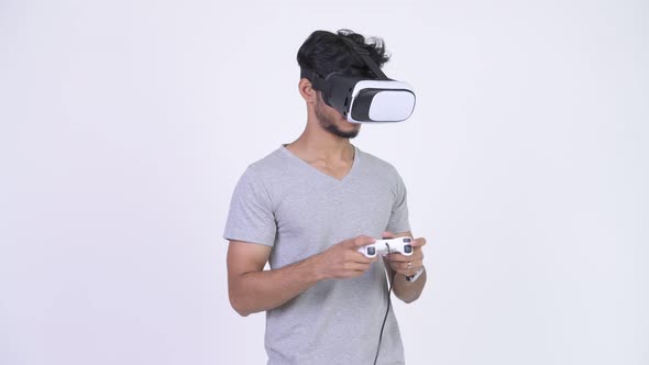Young Handsome Bearded Indian Man Using Virtual Reality Headset While Playing Games