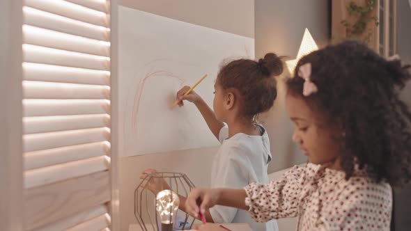 Girls Drawing on Paper on Wall