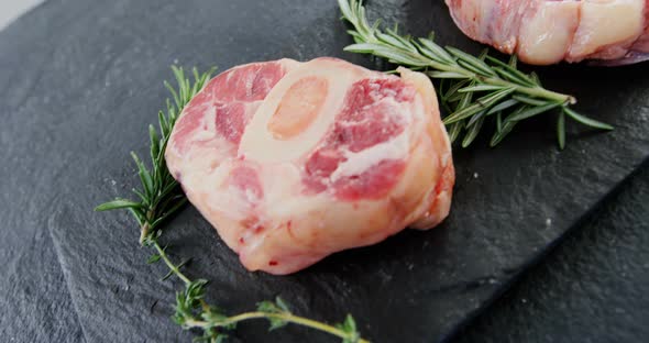 Close-up of sirloin chops and rosemary on chopping board