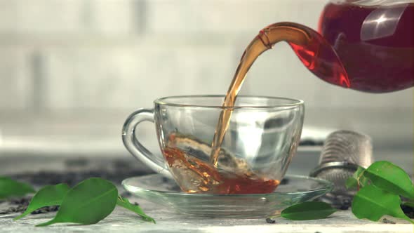 Super Slow Motion From the Teapot is Poured Into a Cup of Black Tea