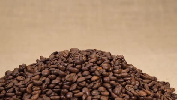 Coffee beans arabica falling isolated on jute background