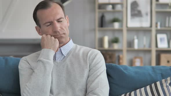 Tired Middle Aged Man Sleeping while Sitting on Couch