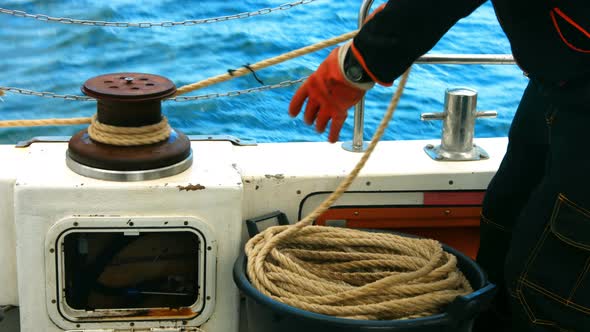 Fisherman tying rope on bollard