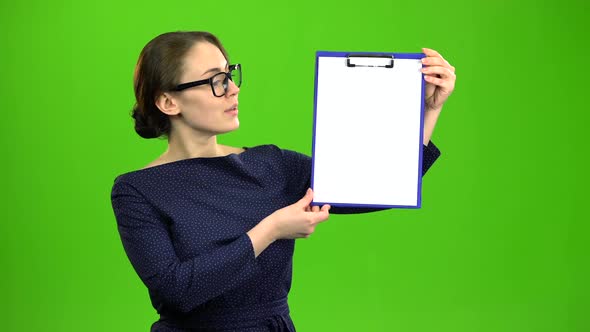 Girl Raises a Paper Tablet and Smiles. Green Screen